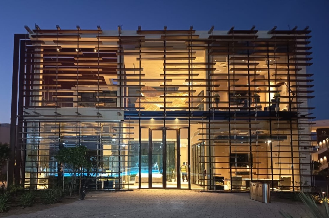 Illuminated contemporary villa behind a horizontal timber screen