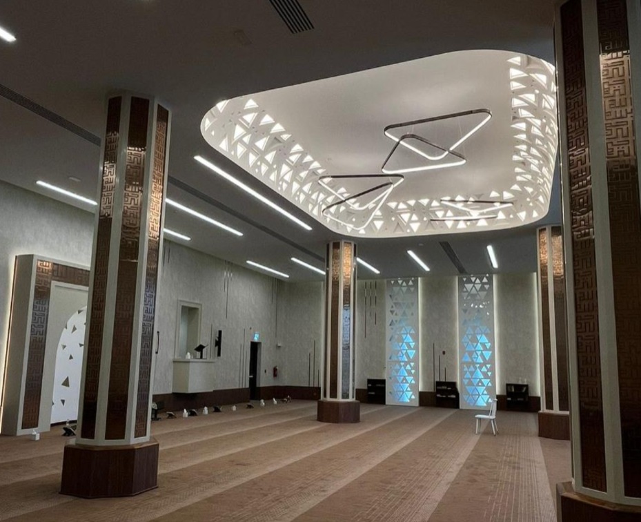 Contemporary prayer hall with illuminated geometric ceiling