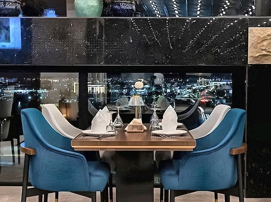 Restaurant table set against a night skyline