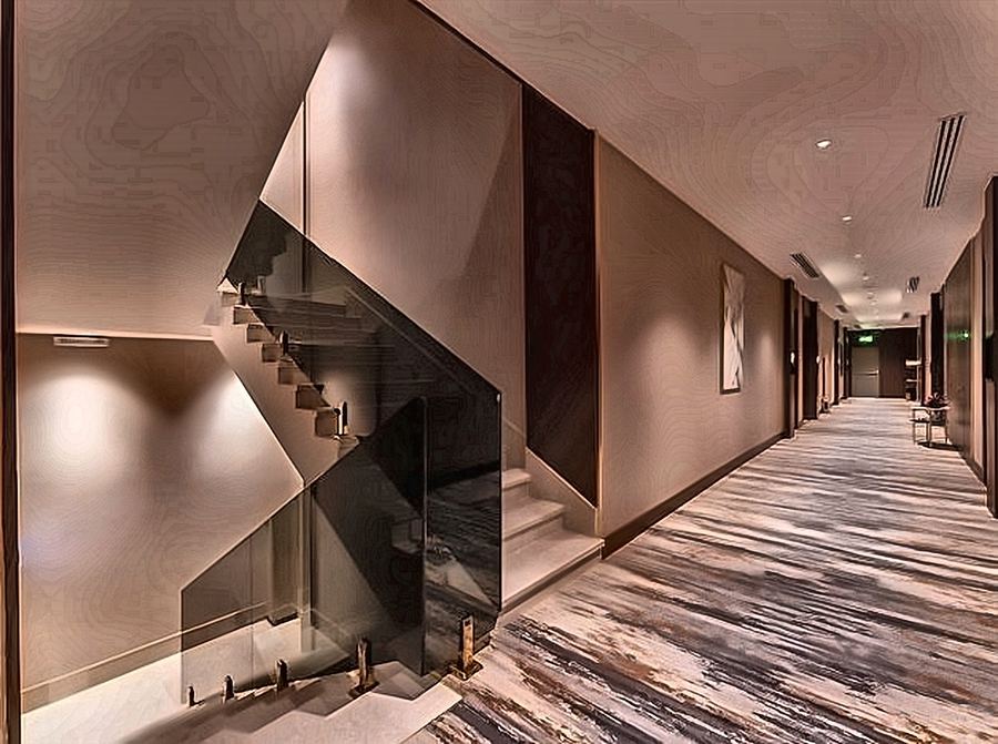 Corridor beside a glass-balustraded stair