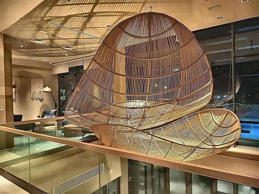 Woven rattan sculpture suspended above a lobby